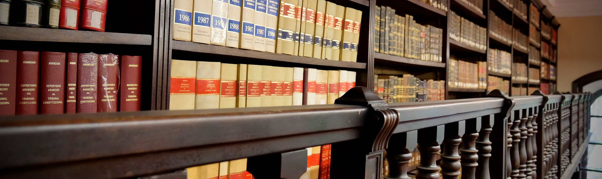 Estanterías llenas de libros en el segundo nivel de la biblioteca de la Facultad de Derecho